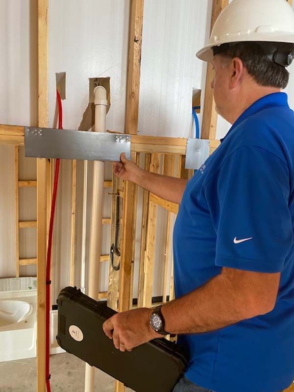 A man wearing a hard hat and a blue shirt has nike on his shirt