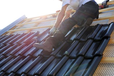 A man is working on the roof of a house.