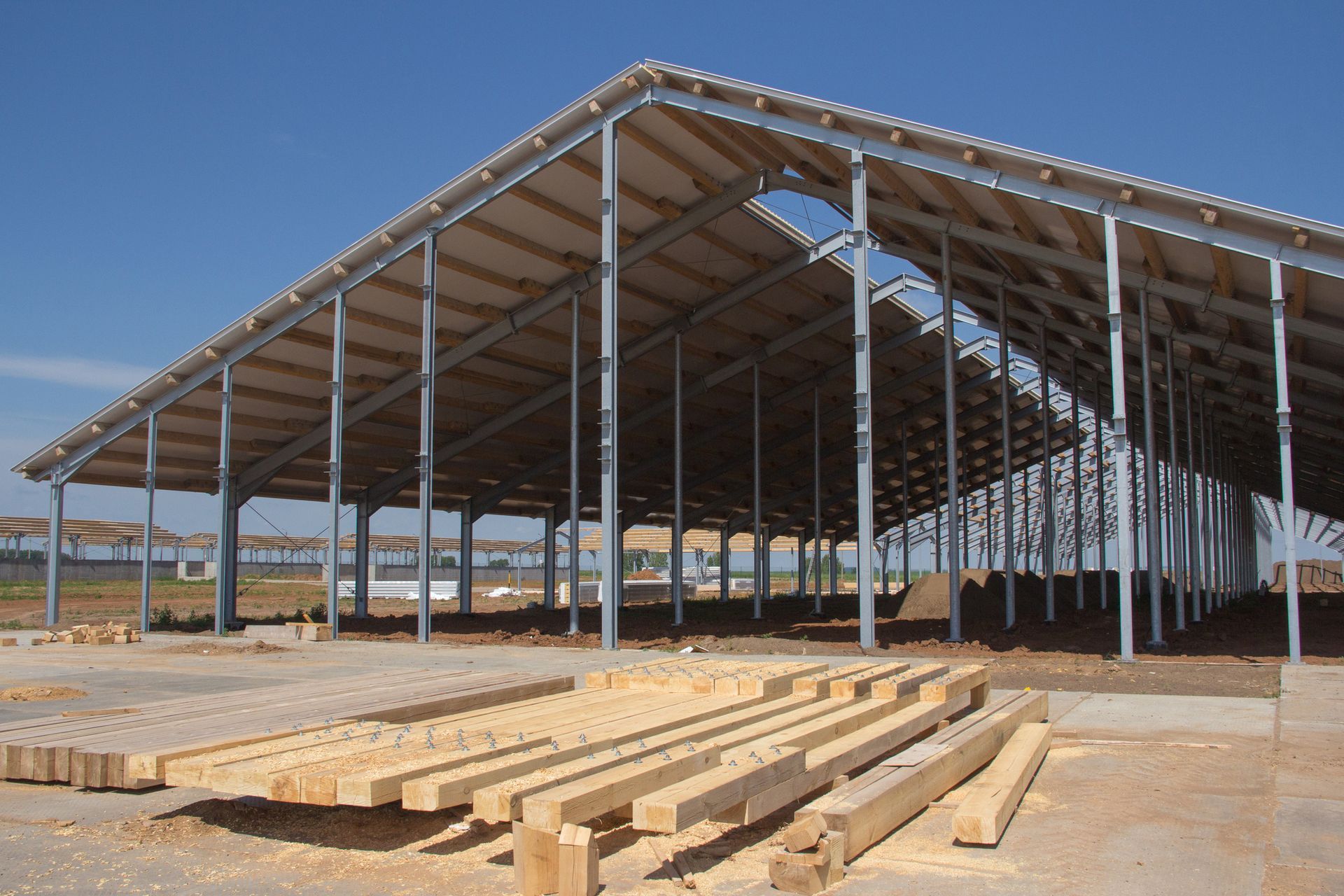 A building under construction with a lot of wood in front of it.