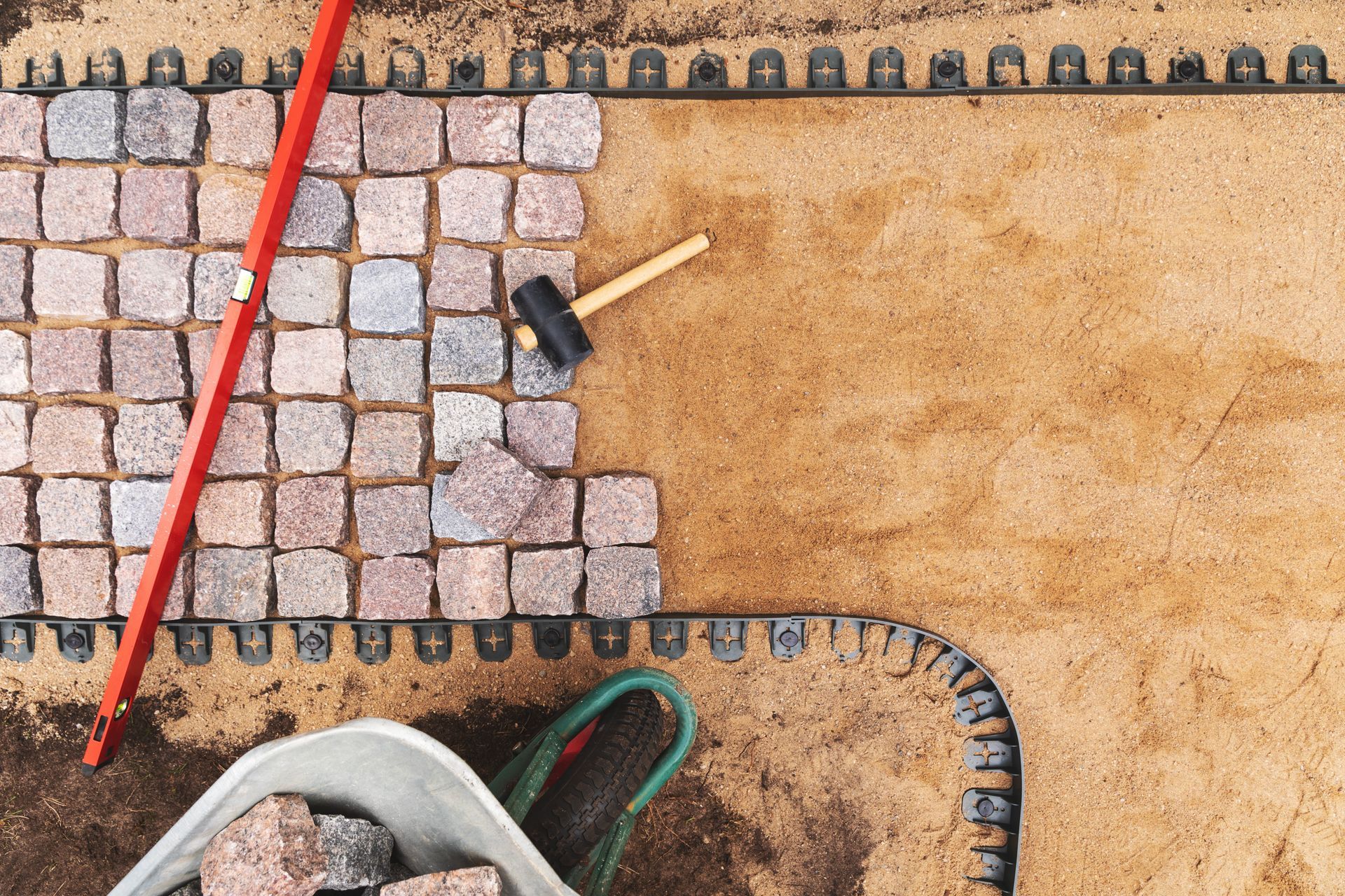 Close-up of a brick walkway featuring various tools scattered across the surface.