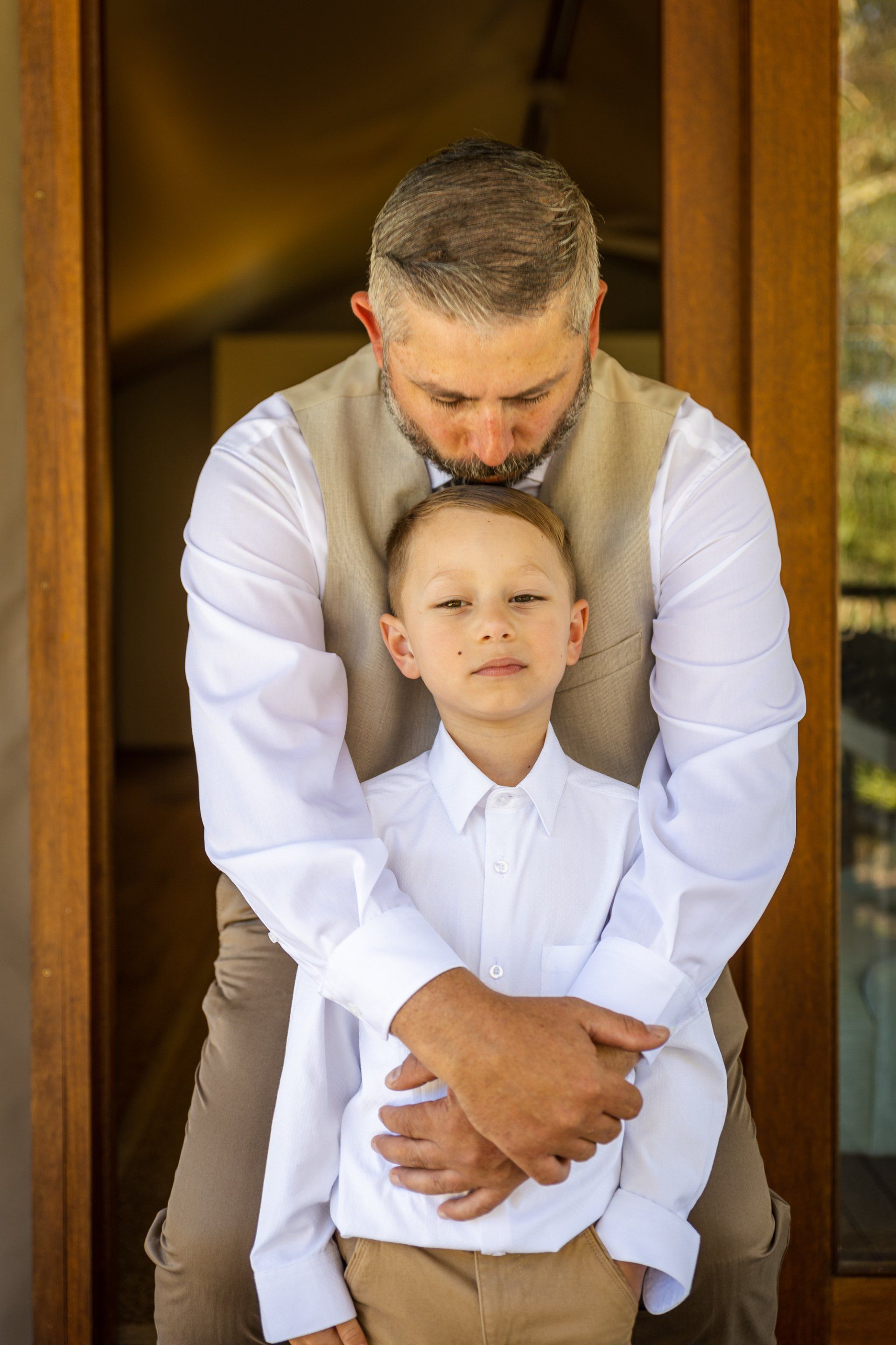 a man is holding a little boy in his arms .