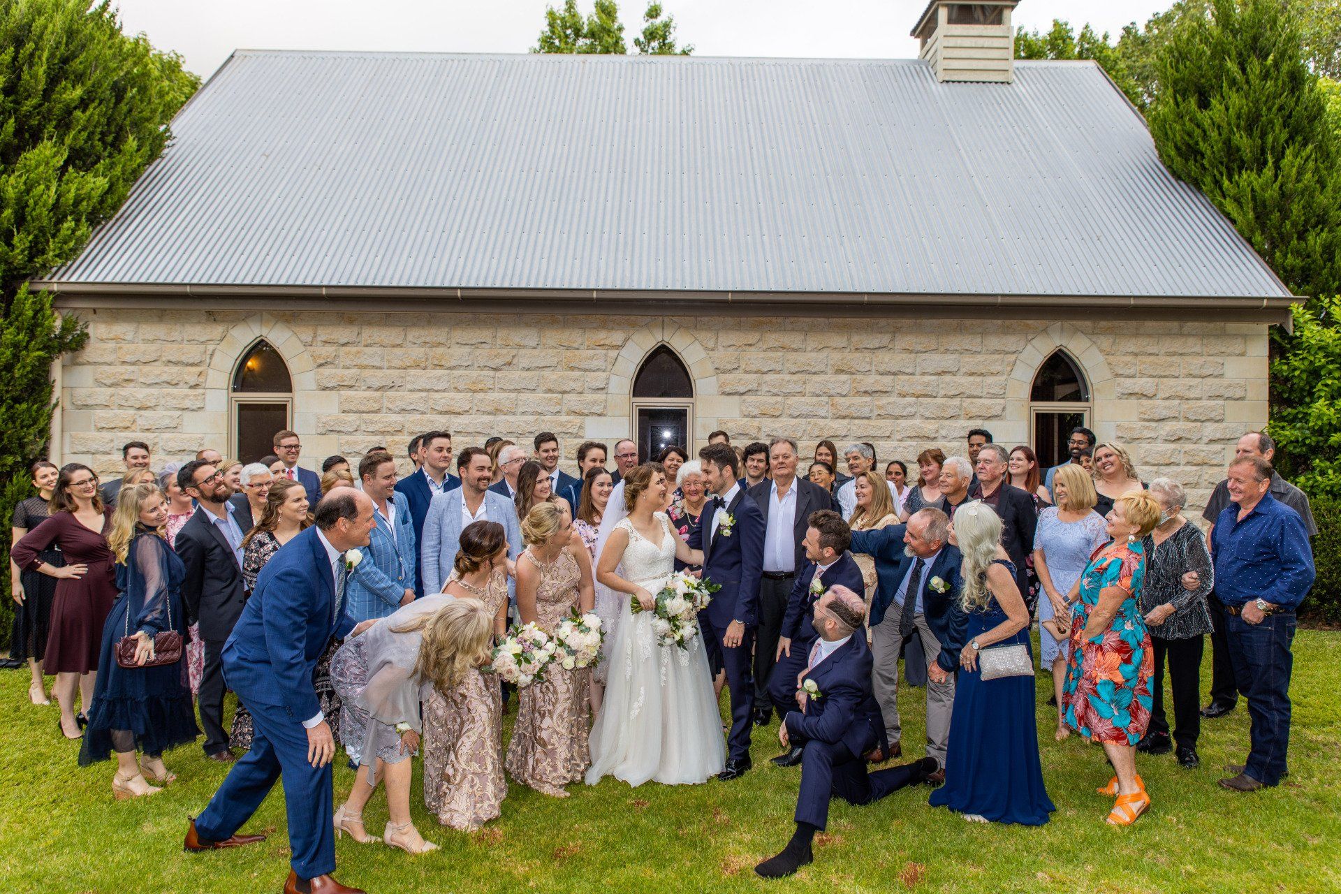 a large group of people are posing for a picture in front of a church .