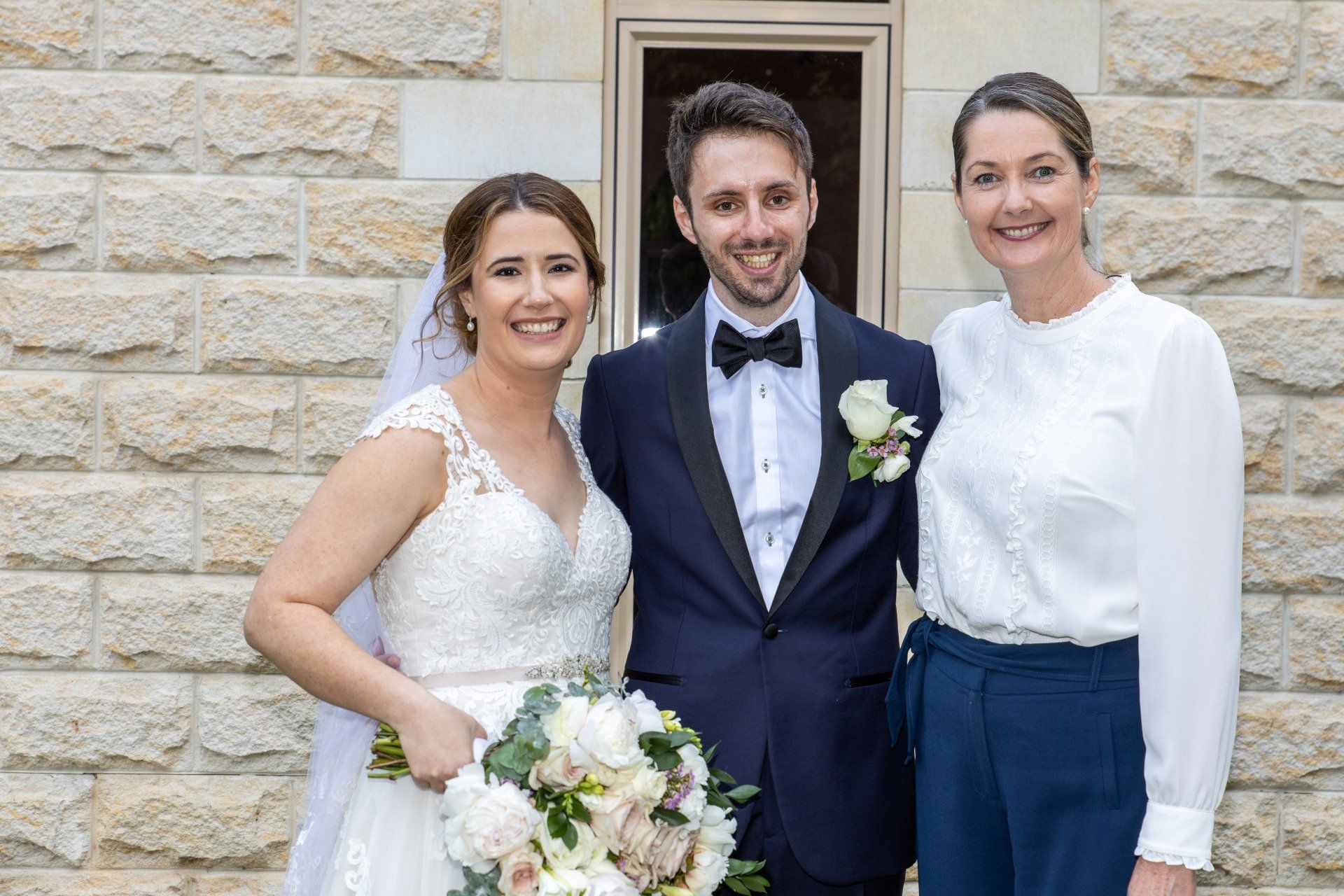 a bride and groom are posing for a picture with two women .
