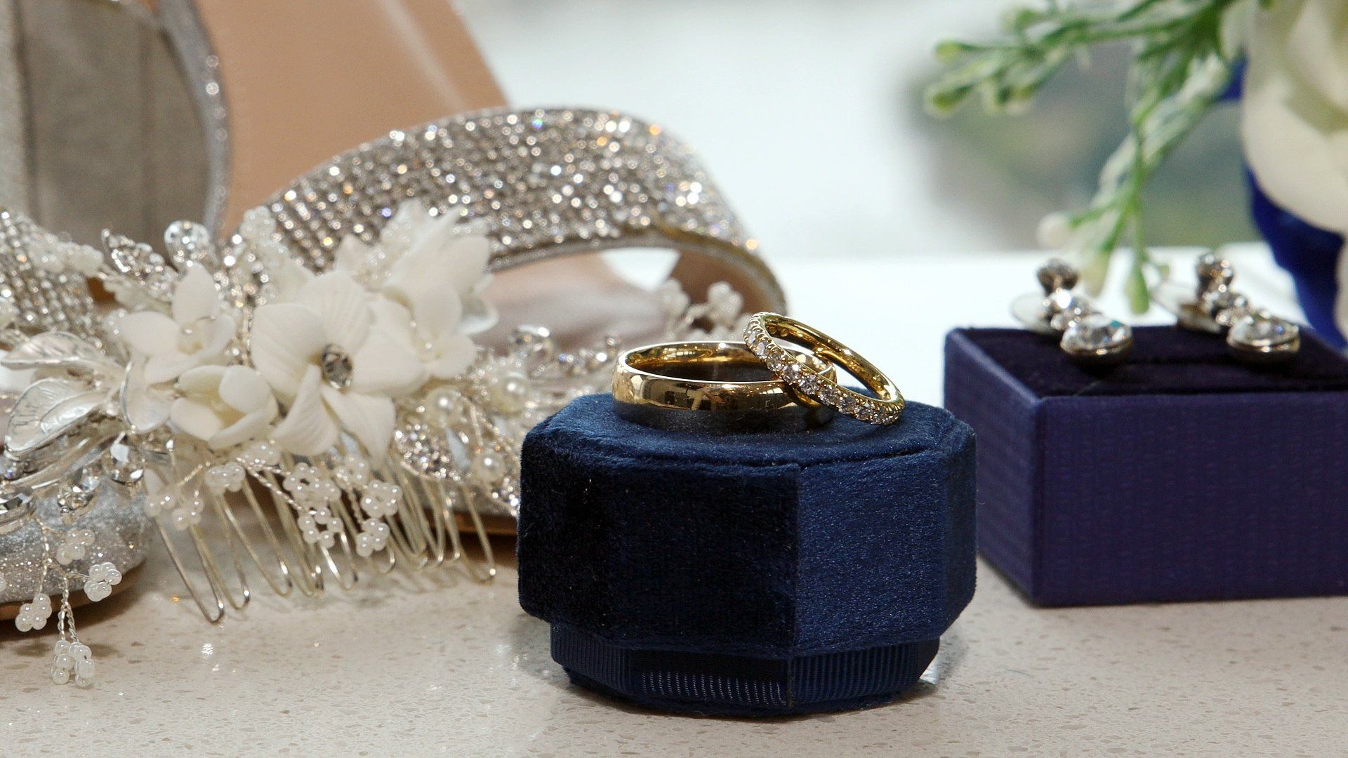 a pair of wedding rings are sitting in a blue box on a table .