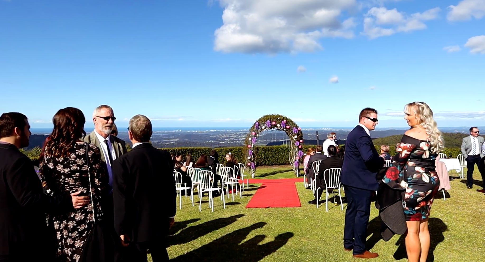 a group of people are standing in a field waiting for a wedding ceremony .Wedding Photography