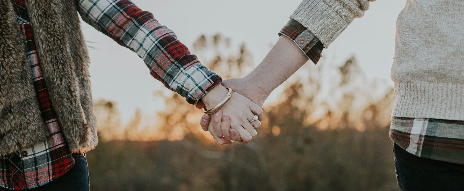 a man and a woman are holding hands in a field .
