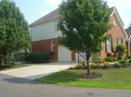 A brick house with a white garage door and a driveway