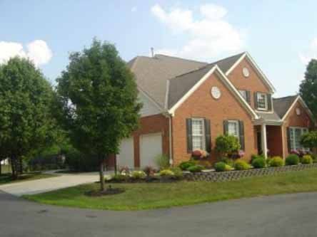 A large brick house with a lot of trees in front of it