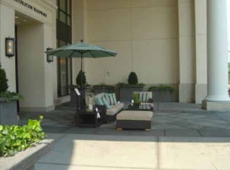 A patio with a couch and umbrella in front of a building