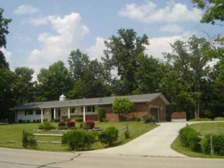 A brick house with a driveway leading to it
