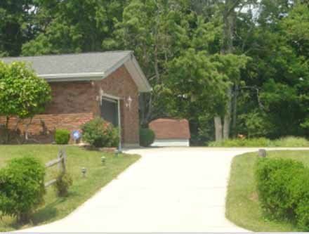 A brick house with a driveway leading to it