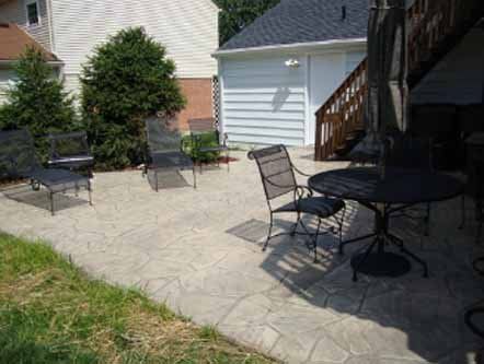 A patio with a table and chairs in front of a house.