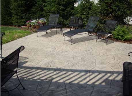 A patio with chairs and a fire pit in the backyard.