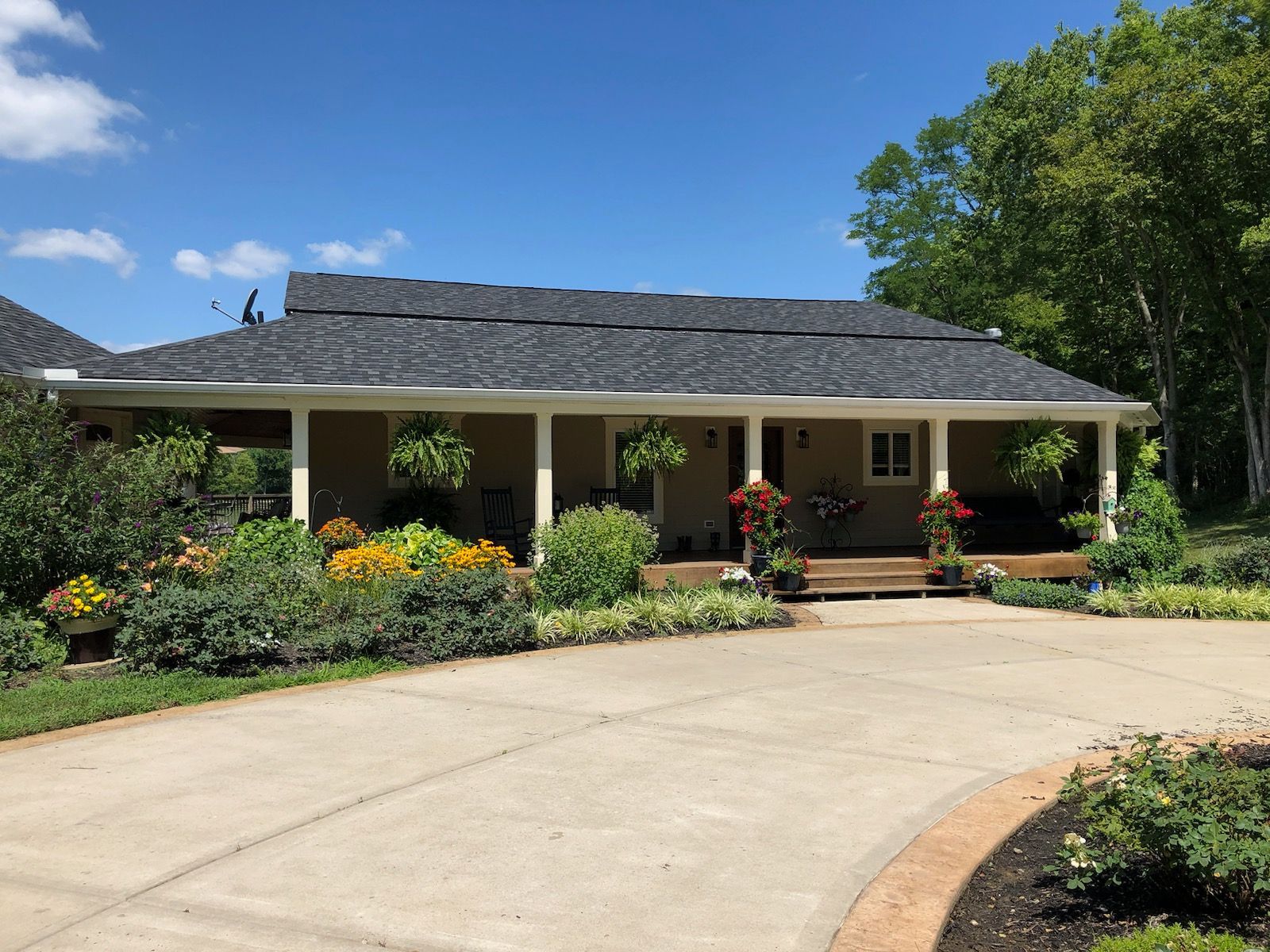 A large house with a large porch and a driveway leading to it.