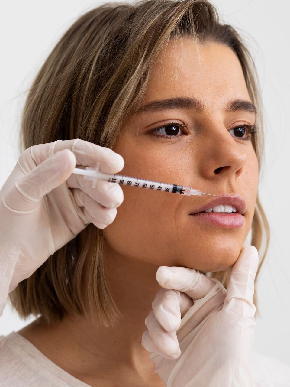 a woman is getting a botox injection in her eye .
