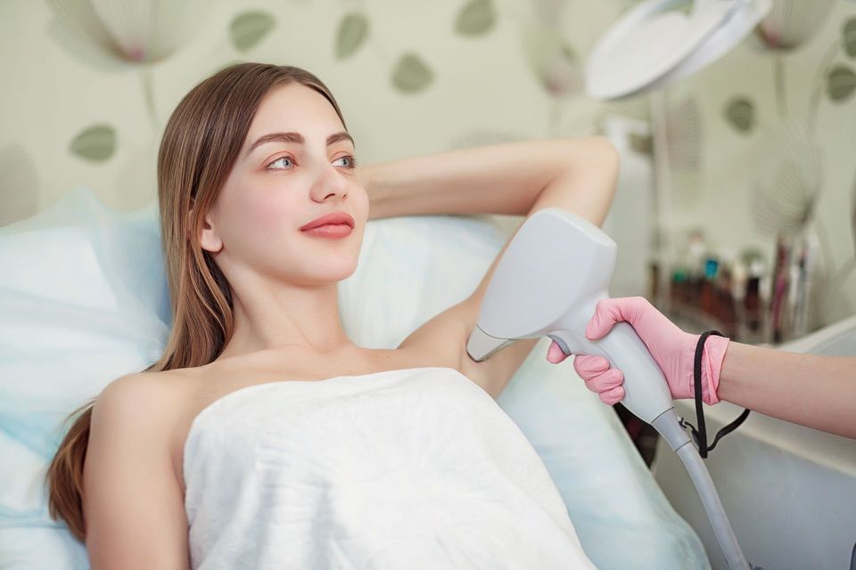 a woman is getting her armpits waxed in a beauty salon .