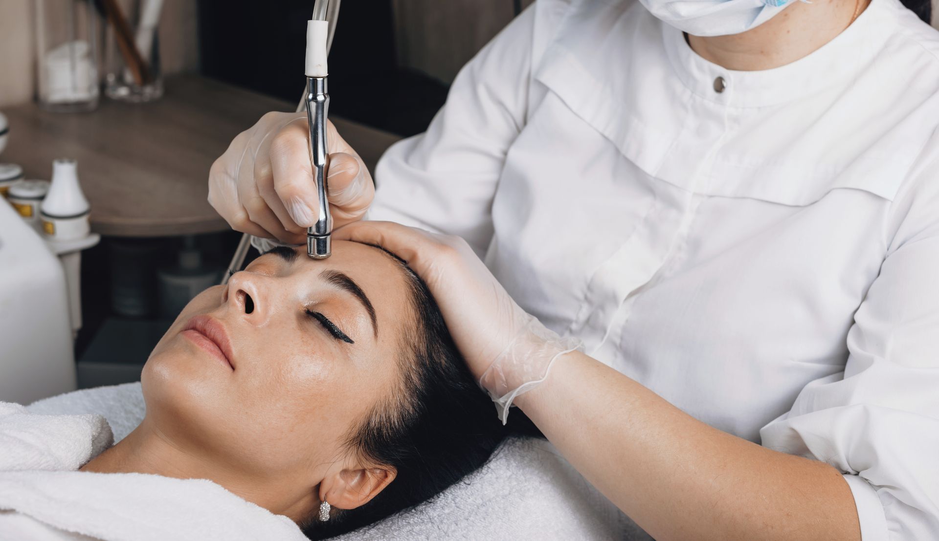 Cosmetic treatment being performed on a woman’s face at a spa clinic