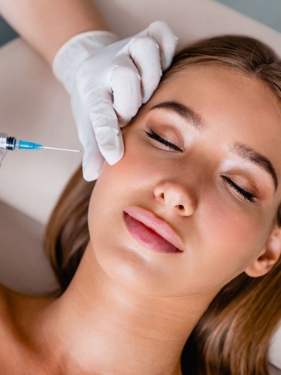 a woman is getting a botox injection in her face .