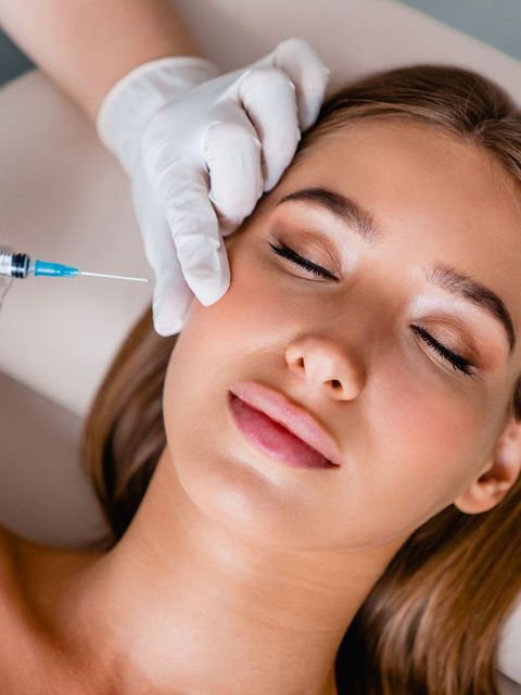 a woman is getting a botox injection in her face .