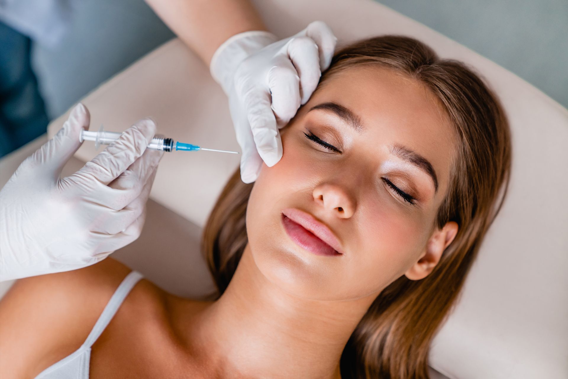 a woman is getting a botox injection in her face .