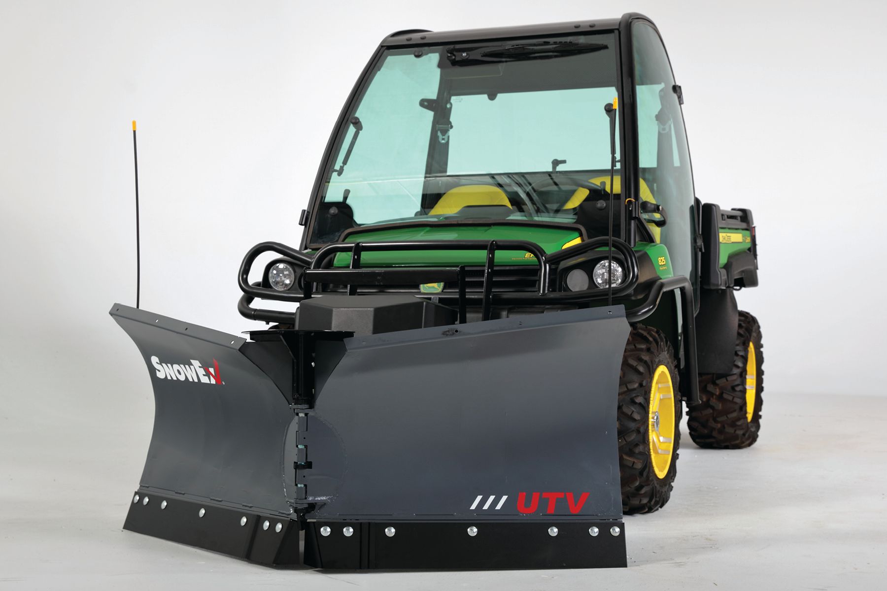 John Deere utility vehicle with snowplow attachment, green and black, on a light background.