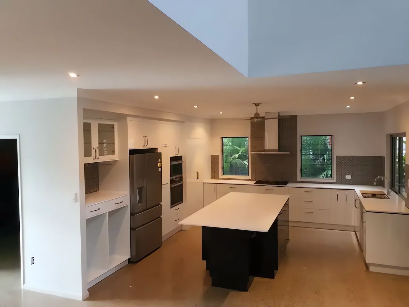 A Kitchen with White Cabinets and A Large Island in The Middle — JWB Joinery in Aitkenvale, QLD