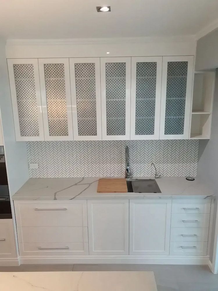 A Kitchen with White Cabinets , a Sink , and A Cutting Board — JWB Joinery in Aitkenvale, QLD