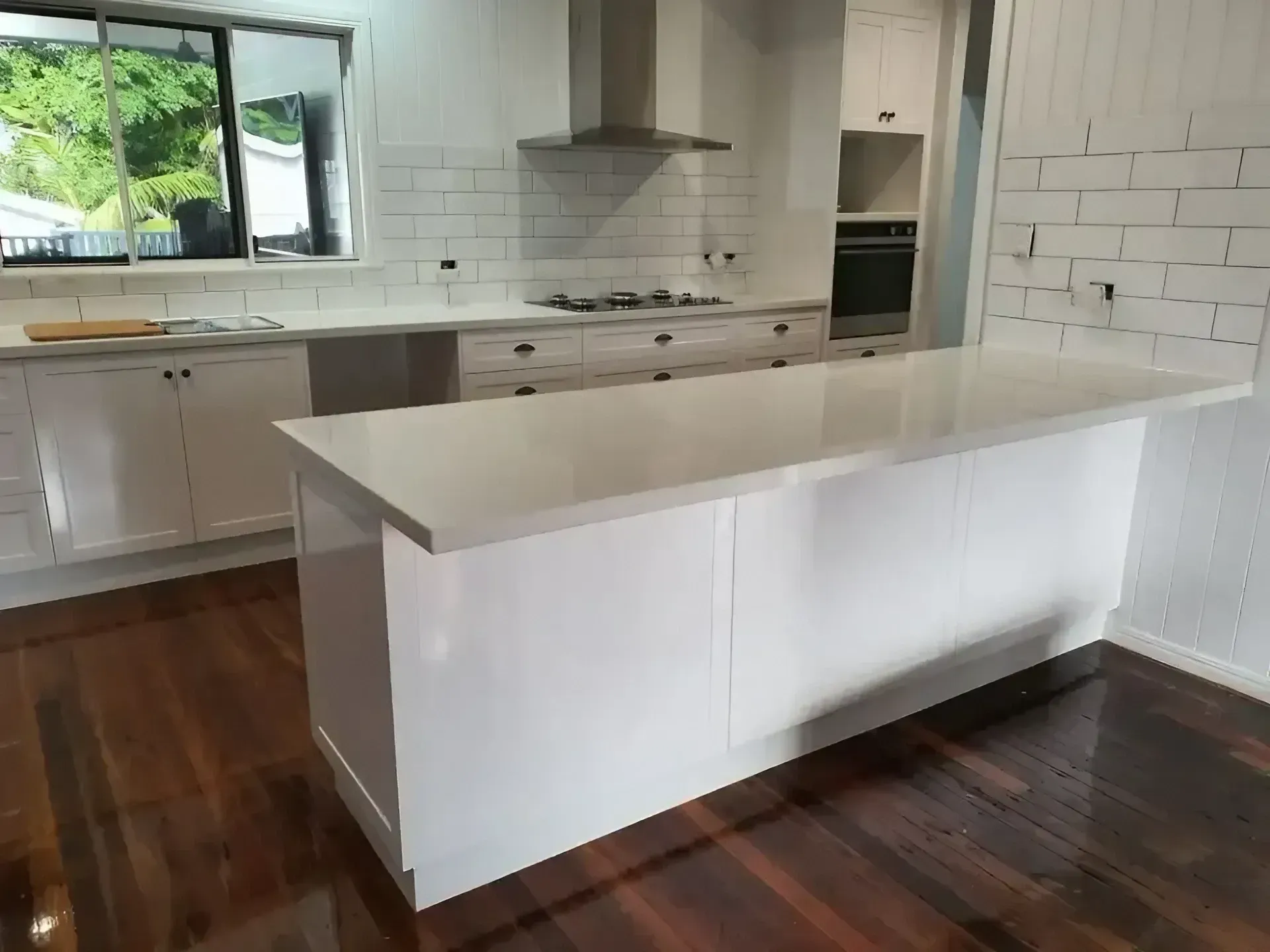 A Kitchen with White Cabinets and A Large Island in The Middle — JWB Joinery in Aitkenvale, QLD
