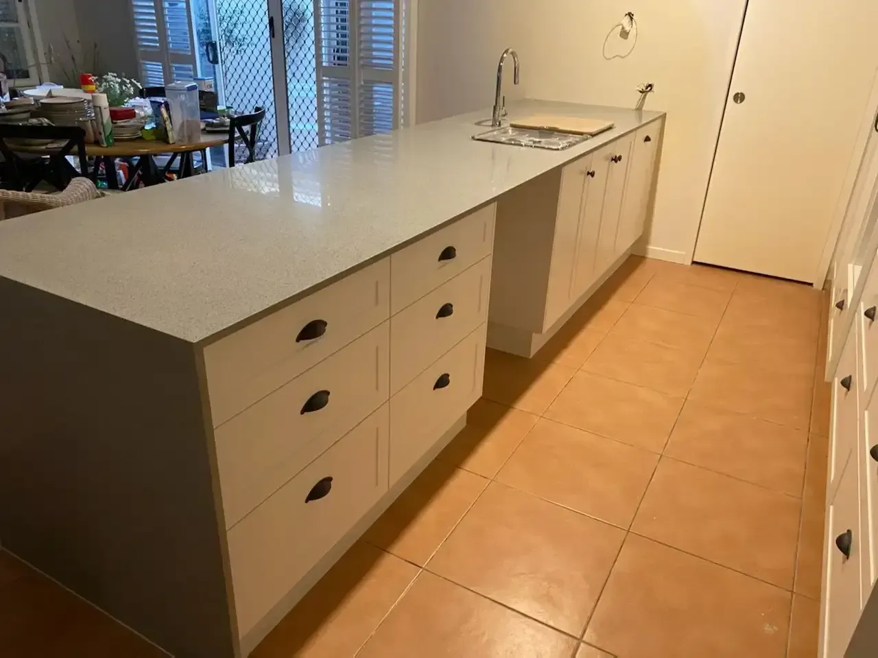 A Kitchen with White Cabinets and A Large Island in The Middle — JWB Joinery in Aitkenvale, QLD
