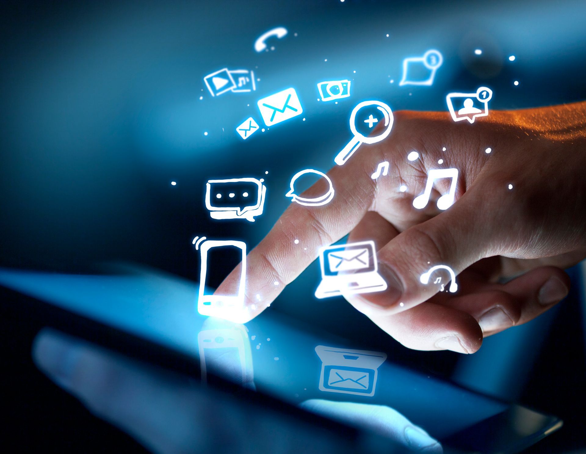 Une main touchant l'écran d'une tablette, entourée d'icônes numériques blanches et lumineuses représentant la communication et la technologie.