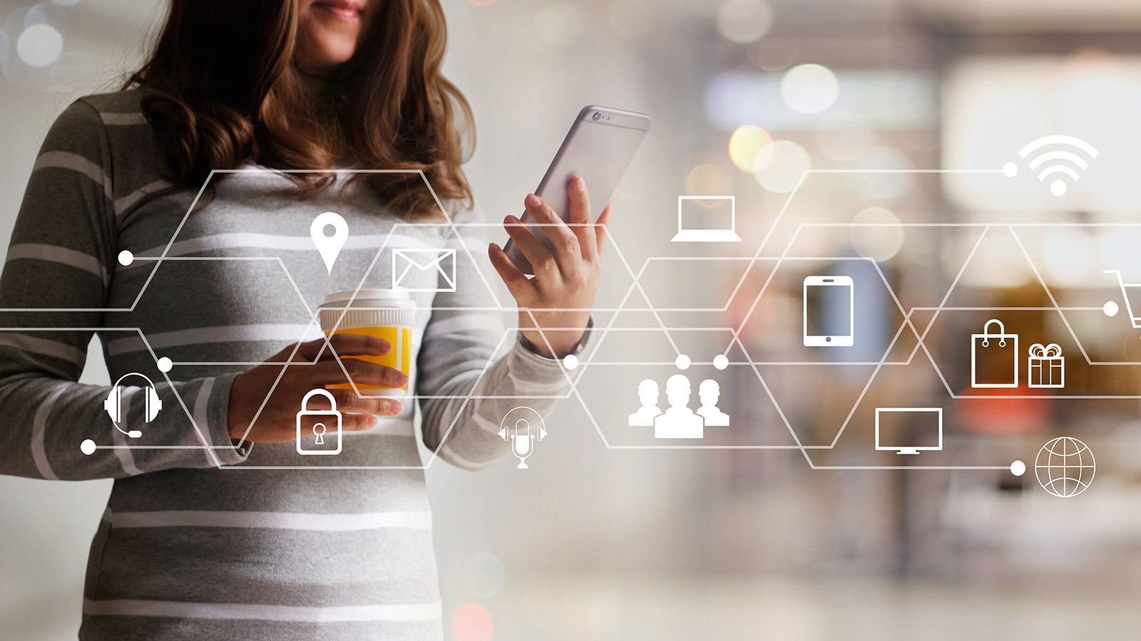Une personne vêtue d'un haut rayé tient un téléphone et une tasse de café sur lesquels se superposent des icônes numériques représentant la connectivité moderne.