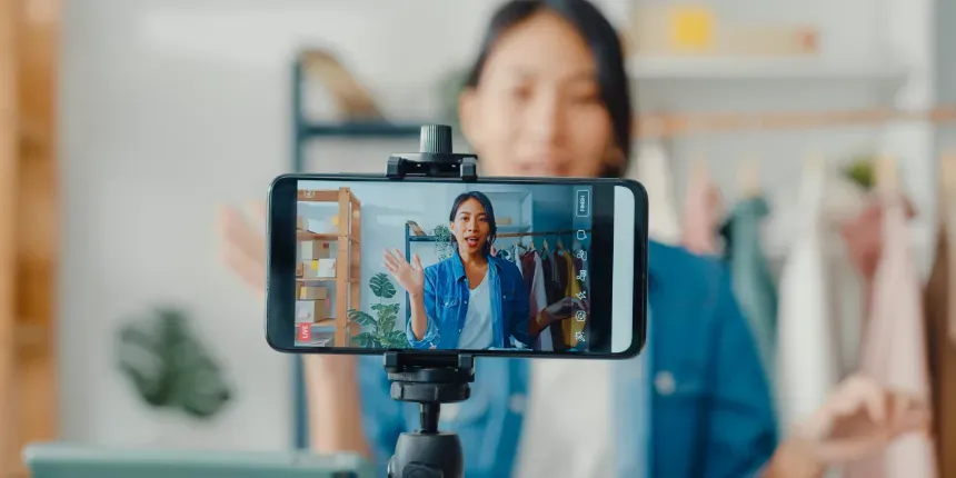 Une femme enregistre une vidéo avec un téléphone portable sur un trépied.