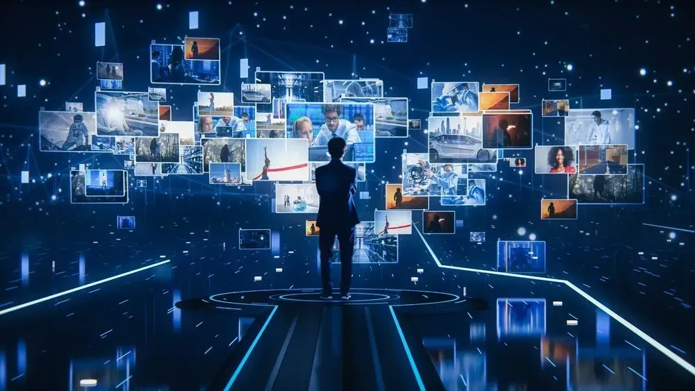 Une personne se tient debout dans un espace sombre et high-tech, observant un ensemble lumineux et flottant d'écrans numériques et de données diverses.