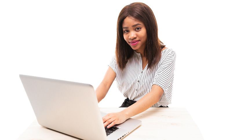 Une femme est assise à un bureau et utilise un ordinateur portable.