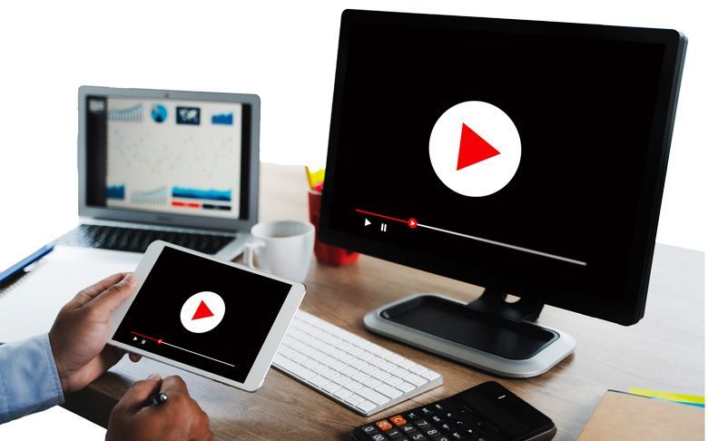 Une personne utilise une tablette et un ordinateur pour regarder une vidéo.
