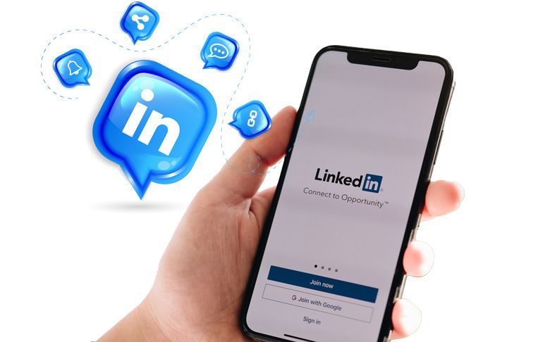 Une personne tient un téléphone portable avec l'application LinkedIn dessus.