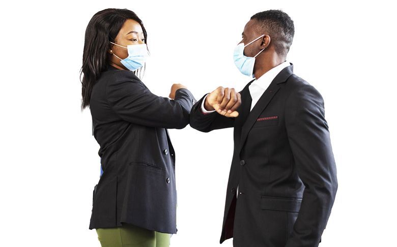 Un homme et une femme portant des masques faciaux se cognent les coudes.