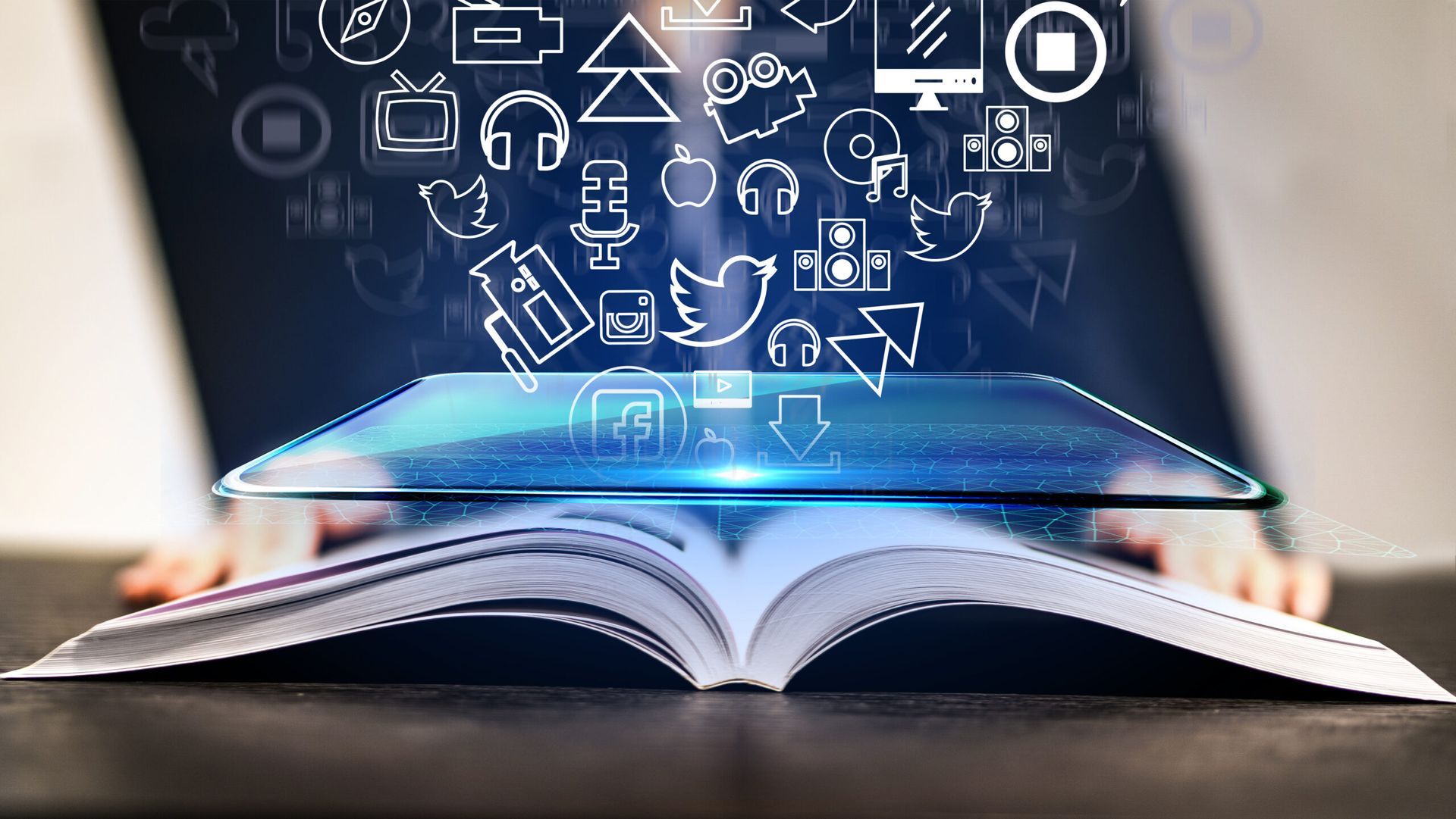 Un livre ouvert surmonté d'une interface numérique lumineuse, entourée de diverses icônes technologiques et médiatiques flottantes.