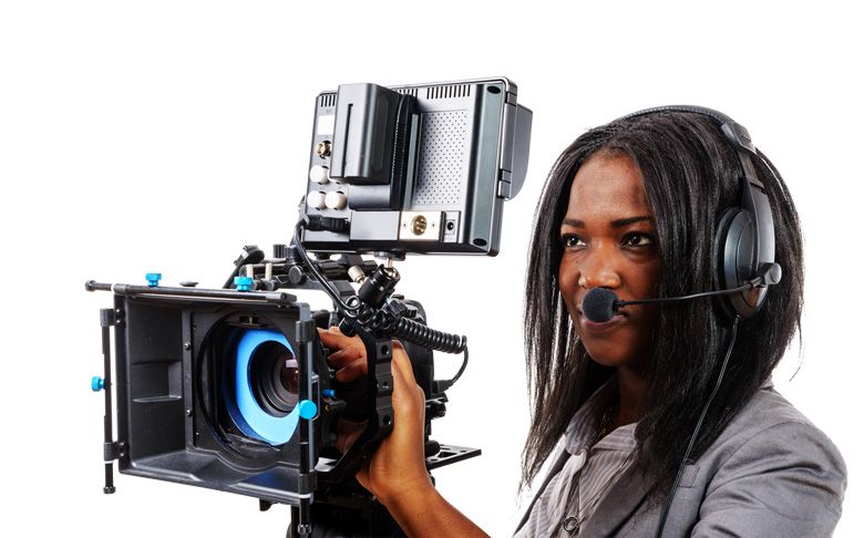 Une femme portant des écouteurs tient une caméra vidéo
