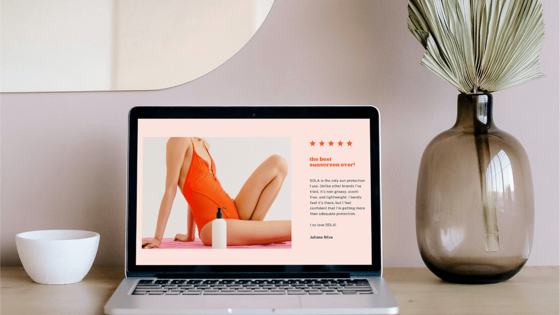 Un ordinateur portable posé sur un bureau affiche une critique de produit pour un soin de la peau, à côté d'un bol blanc et d'un vase en verre contenant des feuilles séchées.