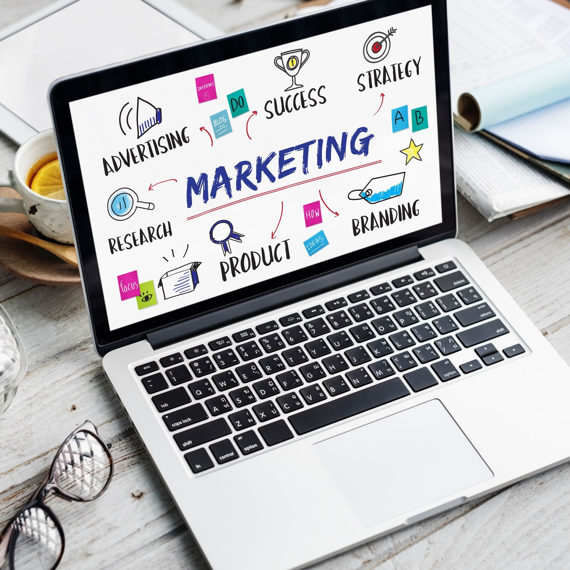 Un ordinateur portable est ouvert sur un écran sur lequel est écrit marketing.