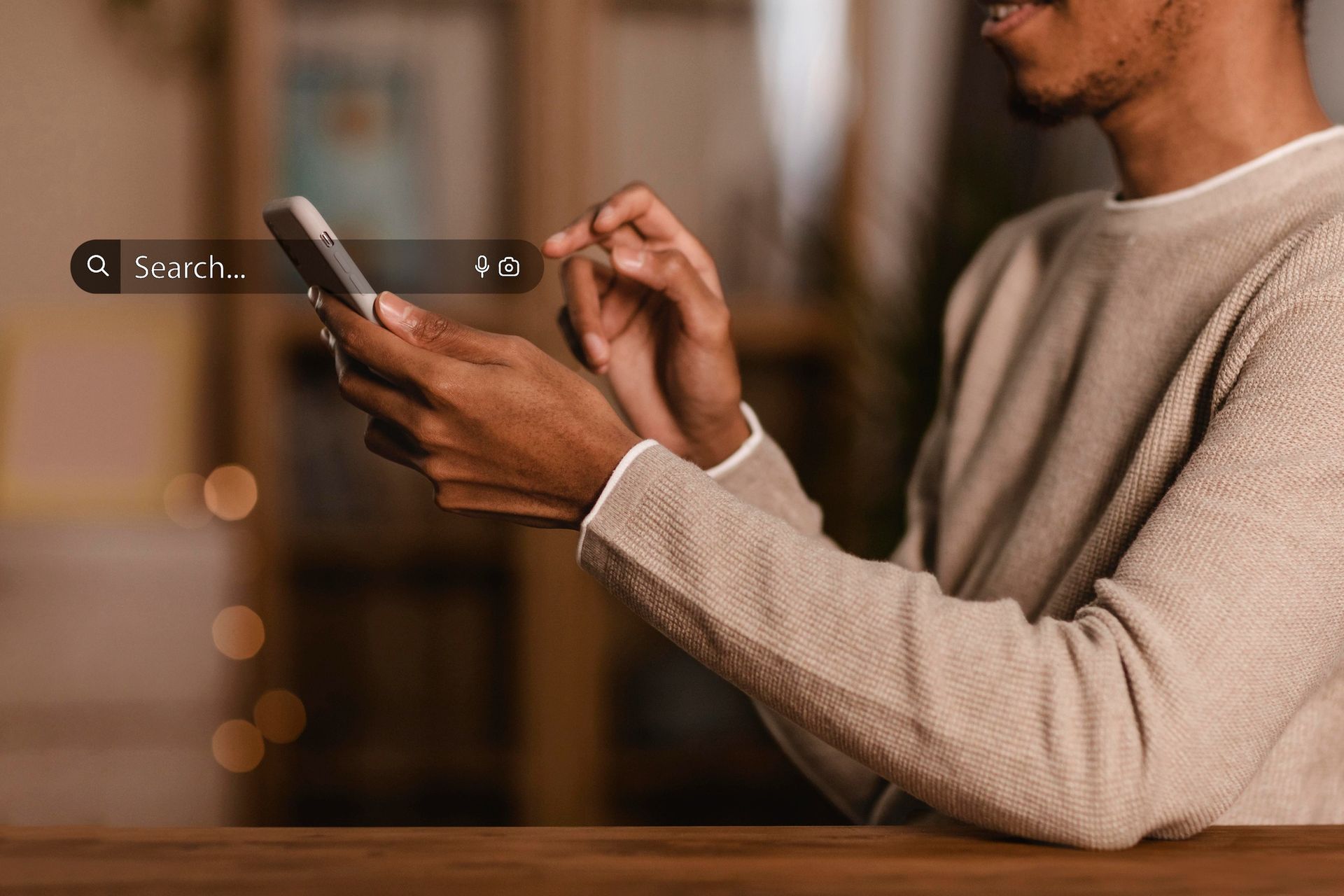 Un homme utilise un téléphone portable assis à une table.