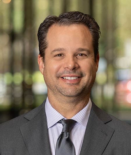 A man in a suit and tie is smiling for the camera.