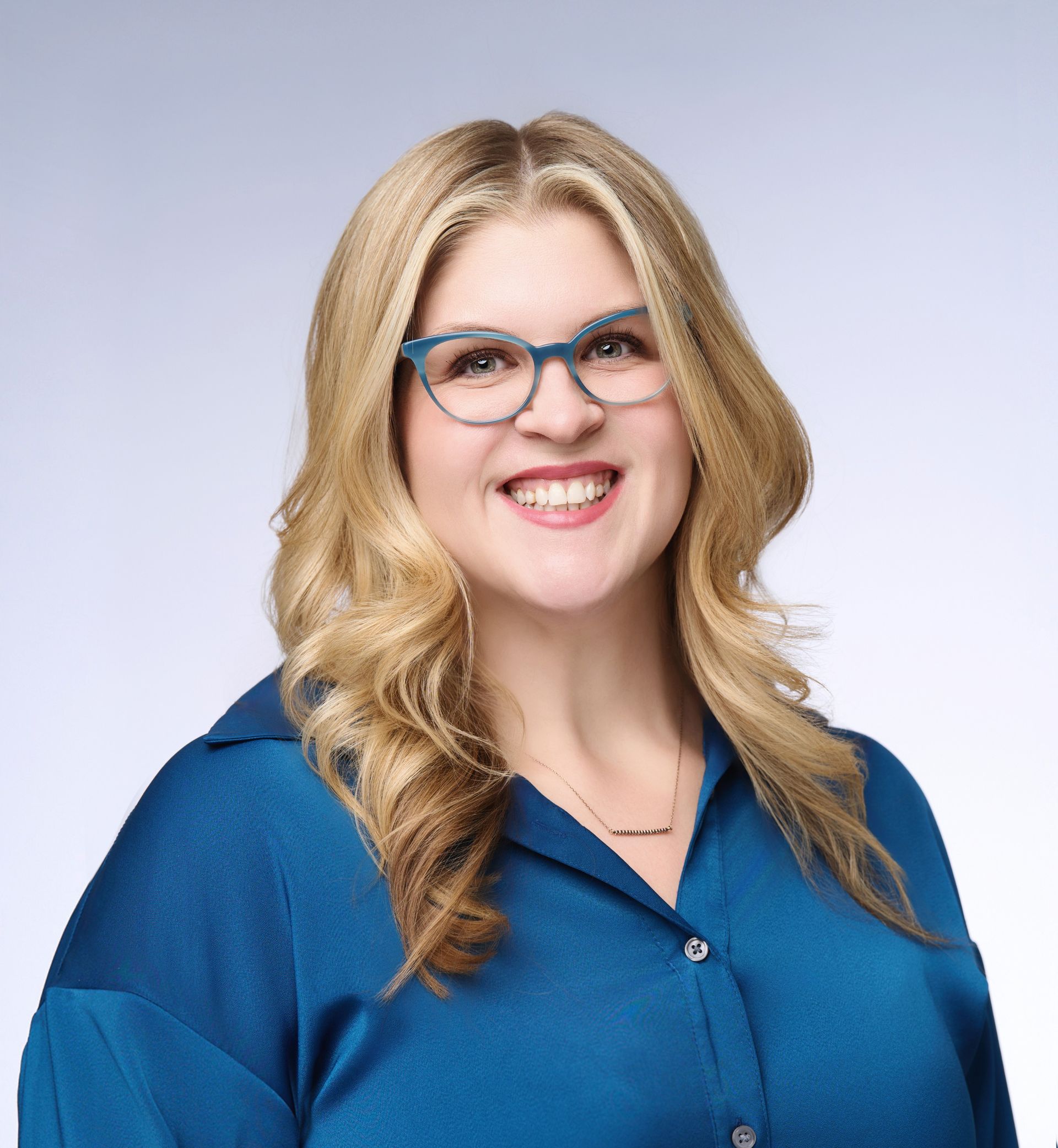 A headshot of Sarah Pais, Advisor Resource Council's CEO, smiling with blonde hair and blue glasses in a blue blouse against a light background