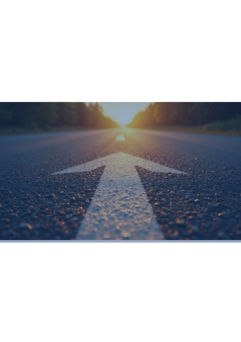 Road arrow pointing toward a bright sunrise on a paved road