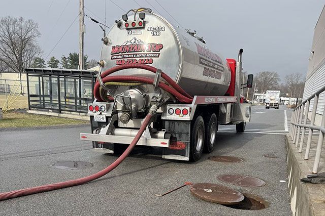 Image of a septic tank grease trap for home use to help collect light liquids such as fats, oils, and grease from the kitchen buried underground with green grass cover.