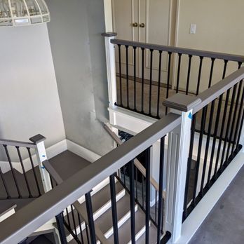 Stairwell with gray railings, black balusters, and beige walls in a home interior