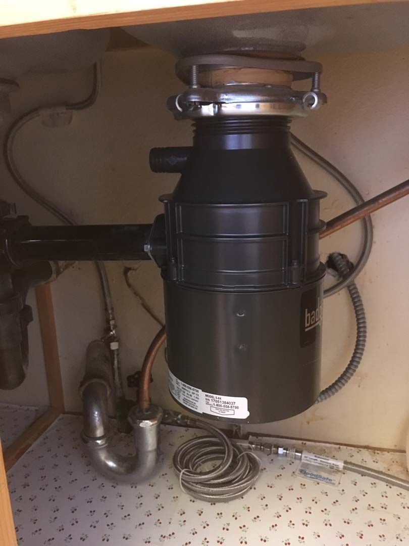 Garbage disposal unit under a kitchen sink.