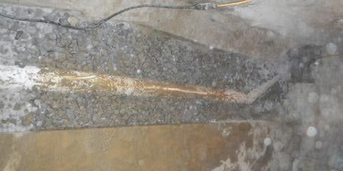 Close-up view of a cement structure, possibly a trough, with a light-colored, linear feature running through it.
