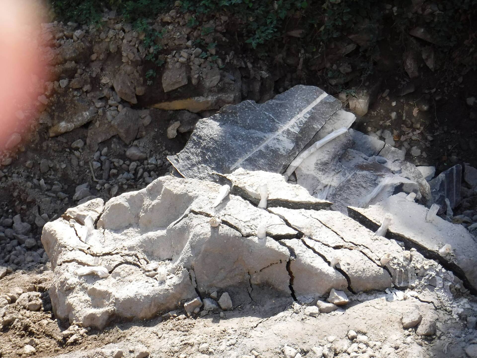 Broken concrete pieces scattered in a dirt area.